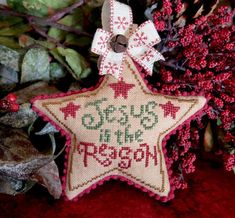 a cross stitch christmas ornament hanging from a tree