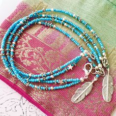 This turquoise beach anklet features a handmade silver feather charm and is intricately beaded with Indian style silver and turquoise glass seed beads. With dual strands and a little silver star added for good measure, this ankle bracelet has an adjustable chain allowing you to personalise the length to fit you perfectly. The strands can sit separately around your ankle or you can twist them together before you do up the clasp for a different look. Threaded onto tigers tail jewellery wire and held together with a slightly larger lobster clasp for ease of use, this turquoise beauty is wonderfully light to wear. Beautiful for a boho bride, day at the beach, casual or evening wear - this is an original myVardoJewellery design.  Your anklet will arrive in our signature beautiful and eco-friend Bohemian Turquoise Beaded Bracelets With Silver Beads, Bohemian Turquoise Beaded Bracelet With Silver Beads, Nickel-free Turquoise Beaded Bracelets For Festivals, Turquoise Beaded Festival Anklets, Blue Beaded Bracelets With Silver Beads For Festivals, Turquoise Anklets With Tiny Beads For Festival, Turquoise Beaded Anklets For Festival, Blue Festival Bracelets With Silver Beads, Blue Bracelets With Silver Beads For Festival