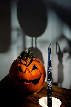 a halloween pumpkin sitting on top of a table next to a pen