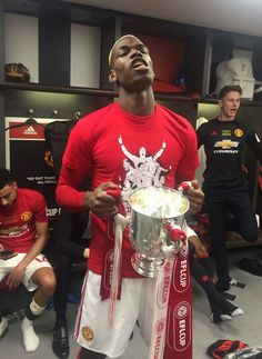 man in red shirt holding up a silver cup