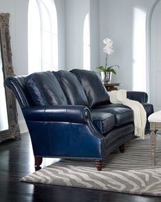 a living room filled with furniture and a zebra rug on top of a hard wood floor