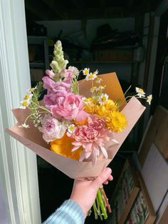 a person holding a bouquet of flowers in their hand