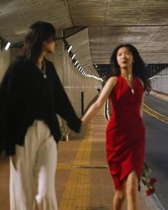 two women walking down a street holding hands