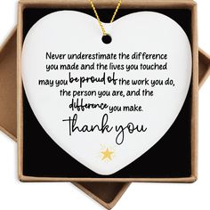 a white heart shaped ornament with a thank message in it's box