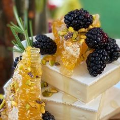 some blackberries and other fruits are sitting on top of each other, with honey in the middle