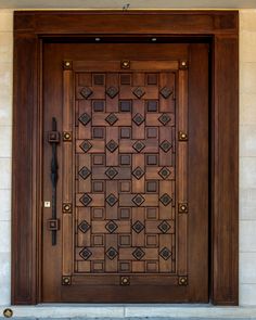 an ornate wooden door with metal handles