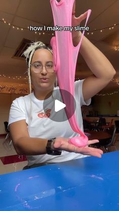 a woman holding up a pink object in her hand with the caption how i make my slime