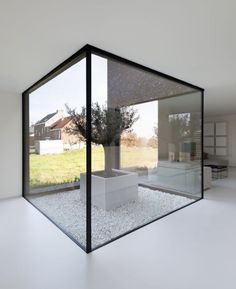 an empty room with glass walls and white flooring