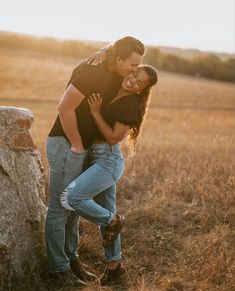 a man and woman hugging in an open field