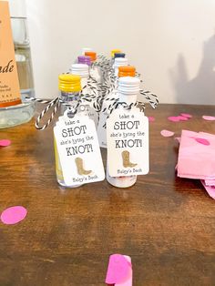 two bottles with labels on them sitting on a table next to confetti cones