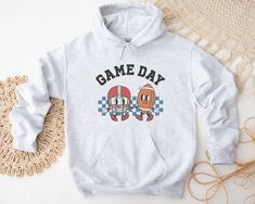 Football Gameday Hoodie, Football Hoodies, Gameday Hoodie, Game Day Hoodie, Football Hooded Sweatshirt, Football Game Sweatshirts  SIZE AND FIT: Your sweatshirt design will be printed on a high-quality, soft and comfortable unisex sweatshirt. Sizes run true to size, which takes the guesswork out of ordering; if you like your sweatshirts loose or oversized, you might want to order a size up and if you'd like a more fitted women's style then order a size down. Please refer to our size chart in the photos for exact dimensions. DETAILS AND FABRIC: * 50% Cotton 50% Polyester * Medium-heavy fabric  * Loose Unisex Fit * Hoodie Brand: Gildan  CARE: - Wash inside out with like colors - Tumble dry low or hang to dry - Non-chlorine bleach only - Do not iron or dry clean PROCESSING : - Your sweatshirt Football Hoodies, Switzerland Flag, Spirit Clothing, Plastic Hangers, Screen Printing Designs, Style Hoodie, Kangaroo Pouch, College Fashion, Heavy Fabric