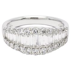 a white gold ring with baguets and diamonds on the sides, set in 18k white gold