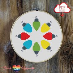 a cross stitch pattern with four different colored umbrellas in the center on a wooden surface