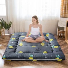 a woman is sitting in the middle of a floor mat with pineapples on it