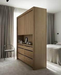 a bed room with a neatly made bed and a wooden cabinet next to the bed