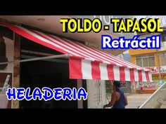 a woman is standing in front of a store with a red and white striped awning