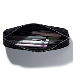 a black purse filled with lots of pens and pencils