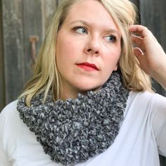 a woman with blonde hair wearing a gray cowl