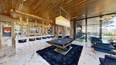 a pool table in the middle of a large room with chairs and tables around it