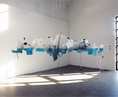 a room filled with lots of white and blue objects hanging from the ceiling in front of a window