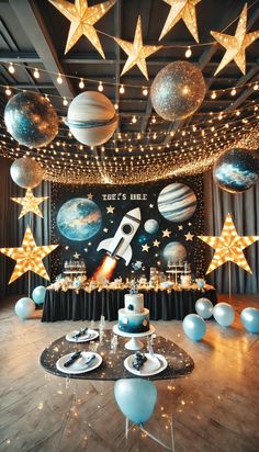 a space themed birthday party with balloons and stars on the ceiling, including a rocket ship