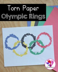 the olympic rings made out of paper on top of a table with scissors and glue