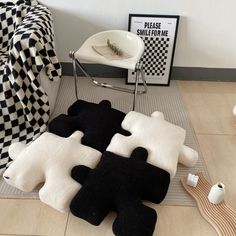 four pieces of black and white rugs on the floor in front of a chair