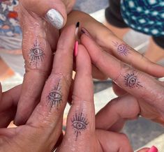 four people with matching tattoos on their fingers