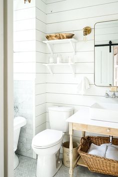 a bathroom with a sink, toilet and shelves on the wall in it's corner