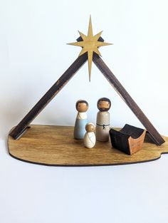 a wooden nativity set with two figurines and a star