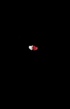 two red and white hearts are in the dark with one heart on it's side