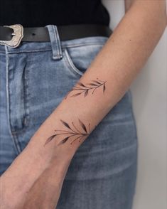 a woman's arm with a small tattoo design on the left side of her wrist