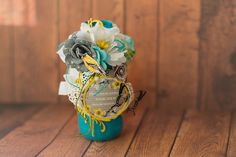 a blue vase filled with flowers on top of a wooden table