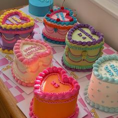 a table topped with lots of cakes covered in frosting