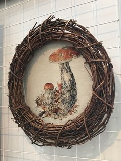 a cross - stitch picture of a mushroom and mushrooms in a nest on the wall