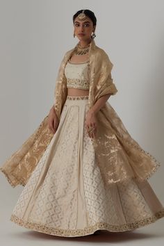 Off white panelled banarasi silk brocade, pure silk lehenga with bloom crest woven details and aari-zardozi embroidery highlights. Paired with a half sleeves floral bloom aari-zardozi embroidered blouse and floral woven banarasi brocade organza dupatta. - Aza Fashions Elegant Brocade Choli With Intricate Embroidery, Elegant Brocade Choli With Sheer Dupatta, Elegant Cotton Silk Choli For Reception, Off White Raw Silk Sets With Traditional Drape, Fitted Off White Raw Silk Traditional Wear, Elegant Brocade Sharara For Transitional Season, Elegant Transitional Brocade Anarkali Set, Elegant Brocade Choli, Elegant Transitional Brocade Sharara