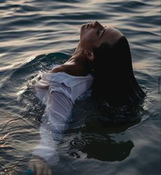 a woman floating in the water with her eyes closed