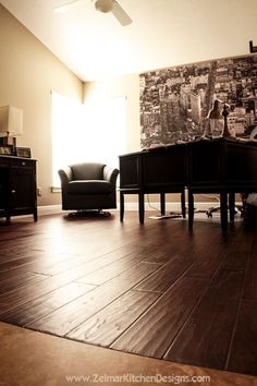 a living room with hard wood flooring and a painting on the wall behind it