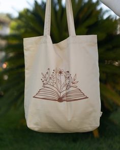 Say goodbye to plastic, and bag your goodies in this organic cotton tote bag. There's more than enough room for groceries, books, and anything in between. * 100% certified organic cotton 3/1 twill * Fabric weight: 8 oz/yd² (272 g/m²) * Dimensions: 16″ × 14 ½″ × 5″ (40.6 cm × 35.6 cm × 12.7 cm) * Weight limit: 30 lbs (13.6 kg) * 1″ (2.5 cm) wide dual straps, 24.5″ (62.2 cm) length * Open main compartment * Blank product components sourced from Vietnam This product is made especially for you as so Books And Flowers, Flowers Tote Bag, Flowers Tote, Open Main, Eco Tote Bag, Cotton Tote Bag, Twill Fabric, Cotton Tote Bags, Fabric Weights