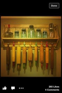 several wooden utensils are hanging on a wall with jars and jars behind them