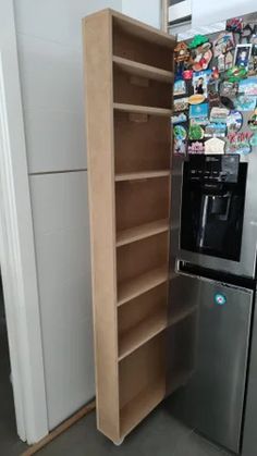 a refrigerator freezer sitting next to a wooden shelf