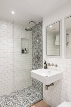 a white bathroom with black and white tile