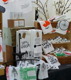 there are many different items on display at this market, including towels and t - shirts