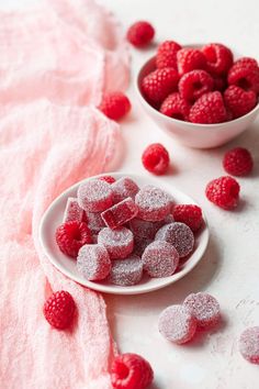 raspberries and powdered sugar in bowls on a white surface with pink linen