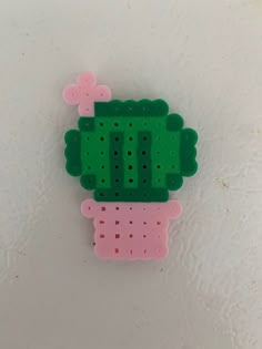 a green and pink piece of plastic with holes in it's center on a white surface