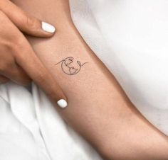 a woman's arm with a small tattoo on the left side of her arm