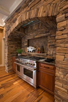 a kitchen with an oven, stove and counter top in stone veneered wall