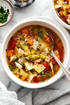 two bowls of vegetable soup on a marble table