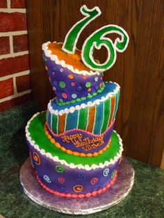 a multi - tiered birthday cake with the number six on top