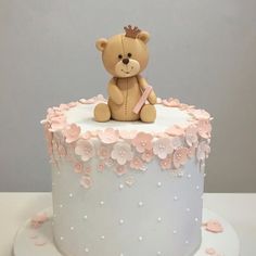 a teddy bear sitting on top of a white cake